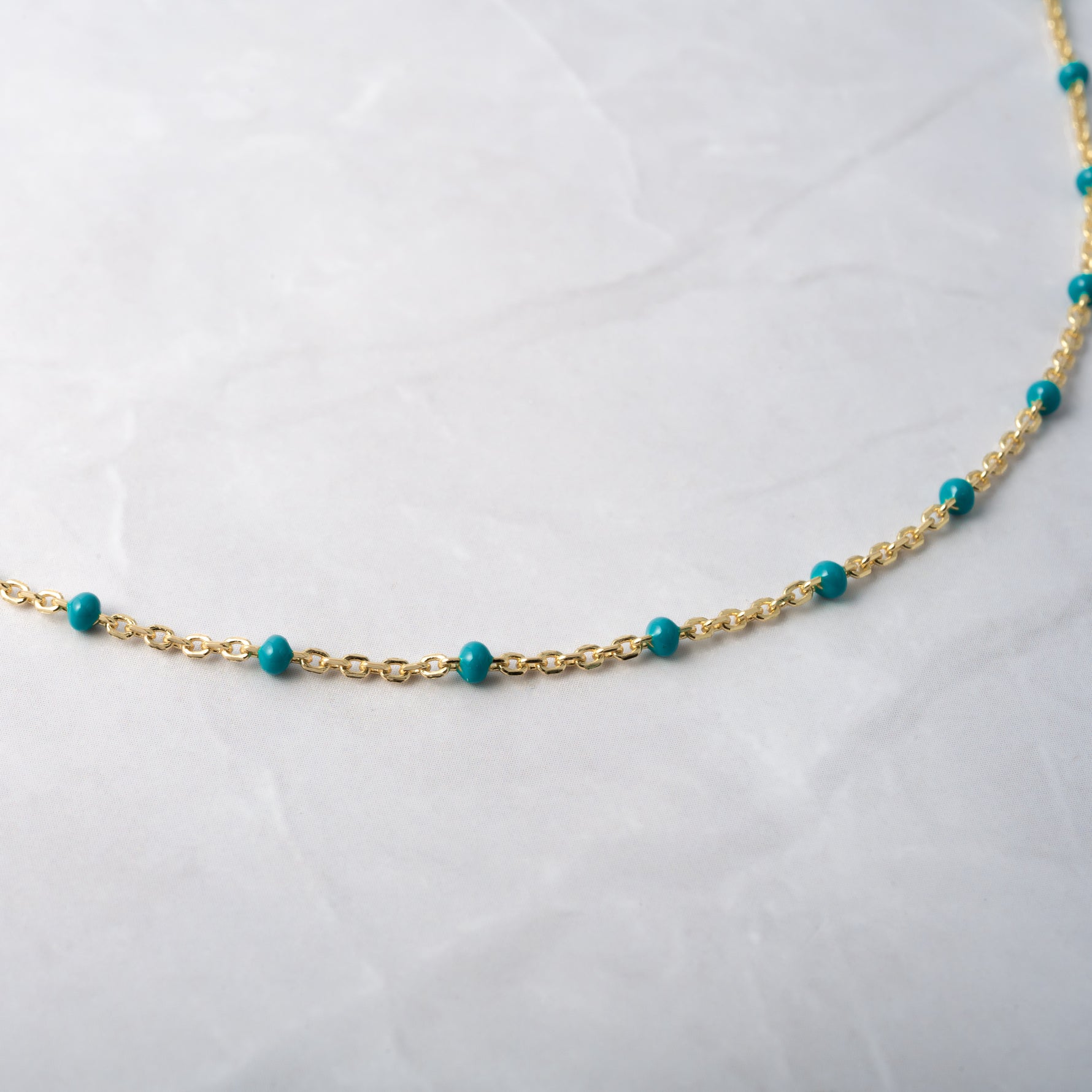 Up-close of turquoise beaded chain necklace. 