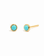 Gold earrings with turquoise stones on a white background