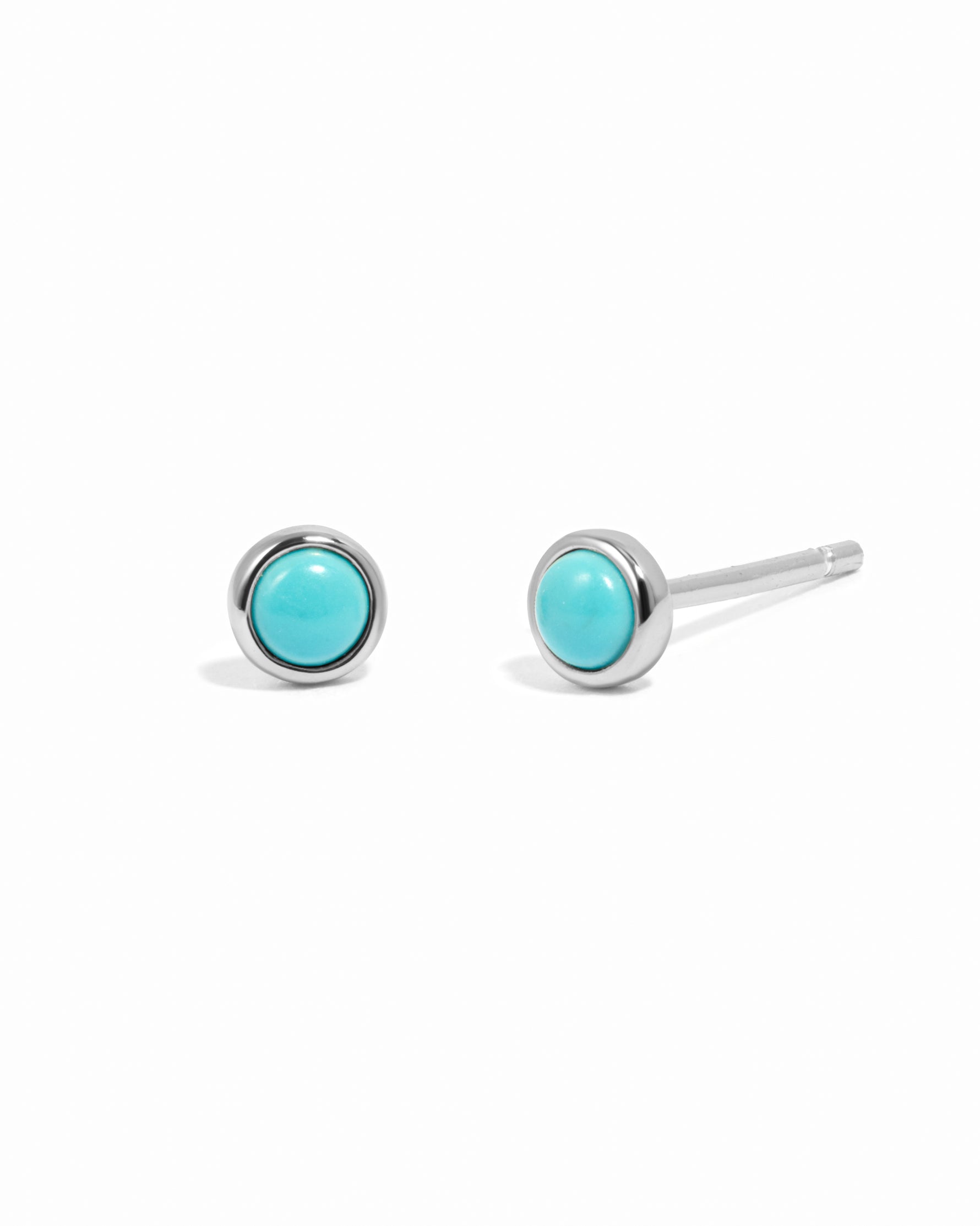 Sterling silver round turquoise stud earrings on white background.
