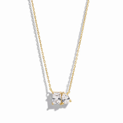 closeup image of gold necklace with pear and emerald cut stone