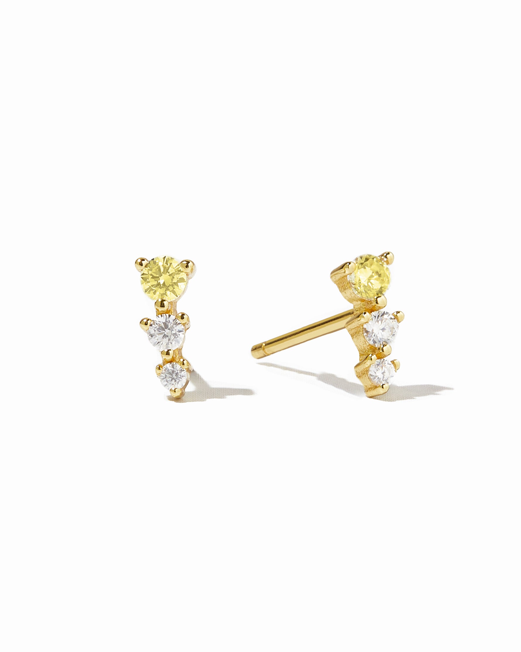 Gold earl climber stud earrings with yellow and diamond stones.