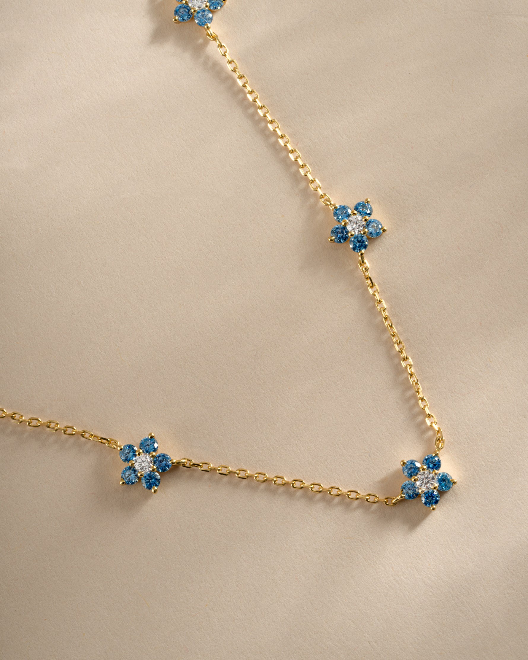 Close-up of Sami Jewels Aqua Flower Necklace featuring a gold chain and detailed aqua flower pendant.