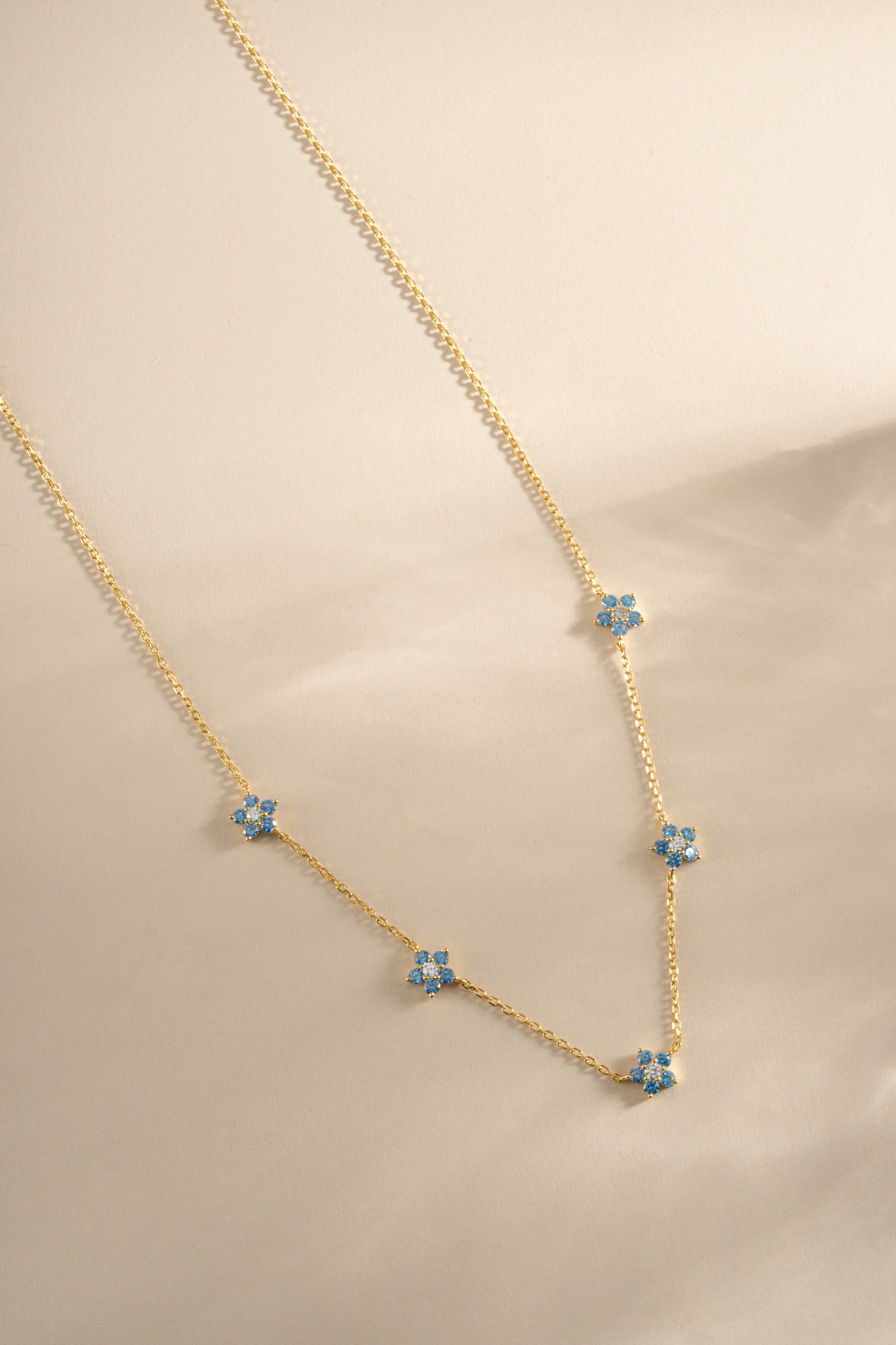 Gold Aqua Flower Necklace from Sami Jewels featuring a delicate aqua flower pendant on a fine chain.