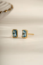 Gold aquamarine baguette stud earrings by Sami Jewels, angled view showing rectangular gemstone design.