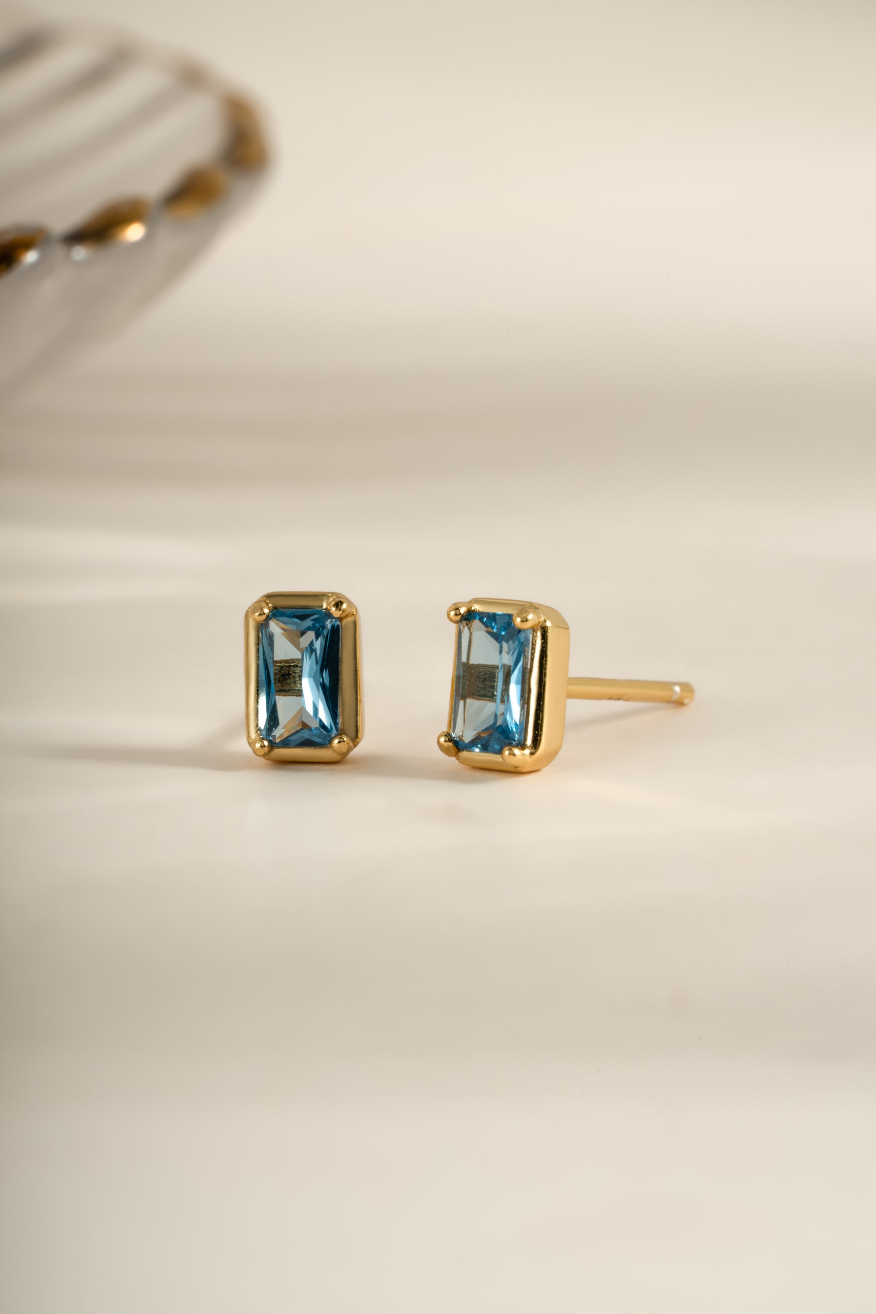 Gold aquamarine baguette stud earrings by Sami Jewels, angled view showing rectangular gemstone design.