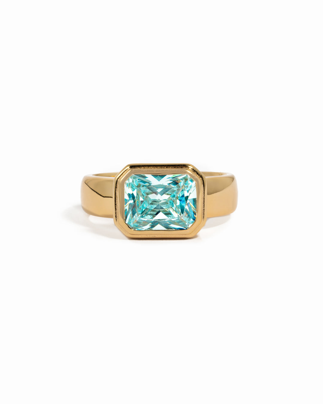 Rectangular aquamarine bezel ring by Sami Jewels featuring a gold band and baguette-cut aquamarine gemstone.