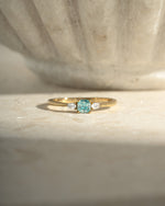aquamarine cushion ring in gold on a neutral background