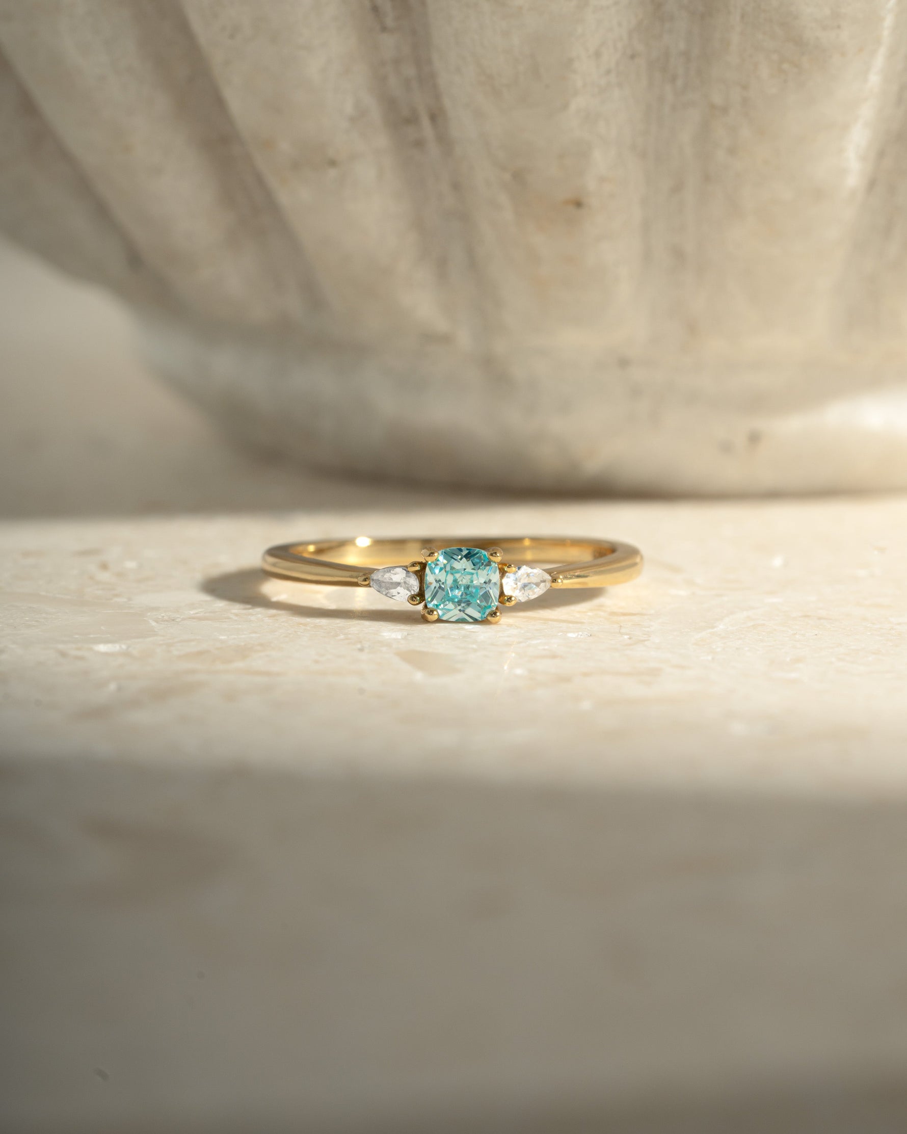 aquamarine cushion ring in gold on a neutral background
