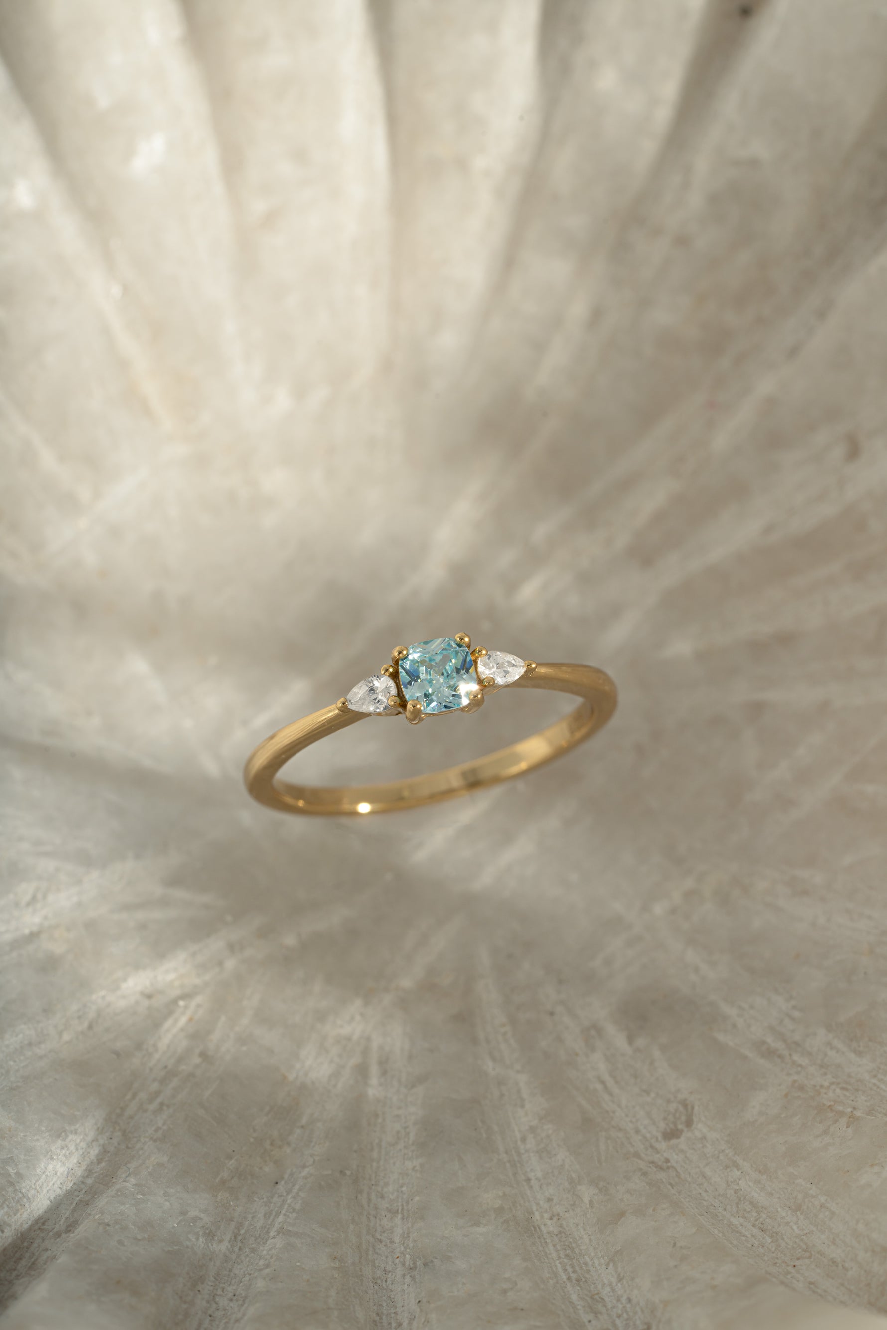 aquamarine cushion ring in gold on a simple background