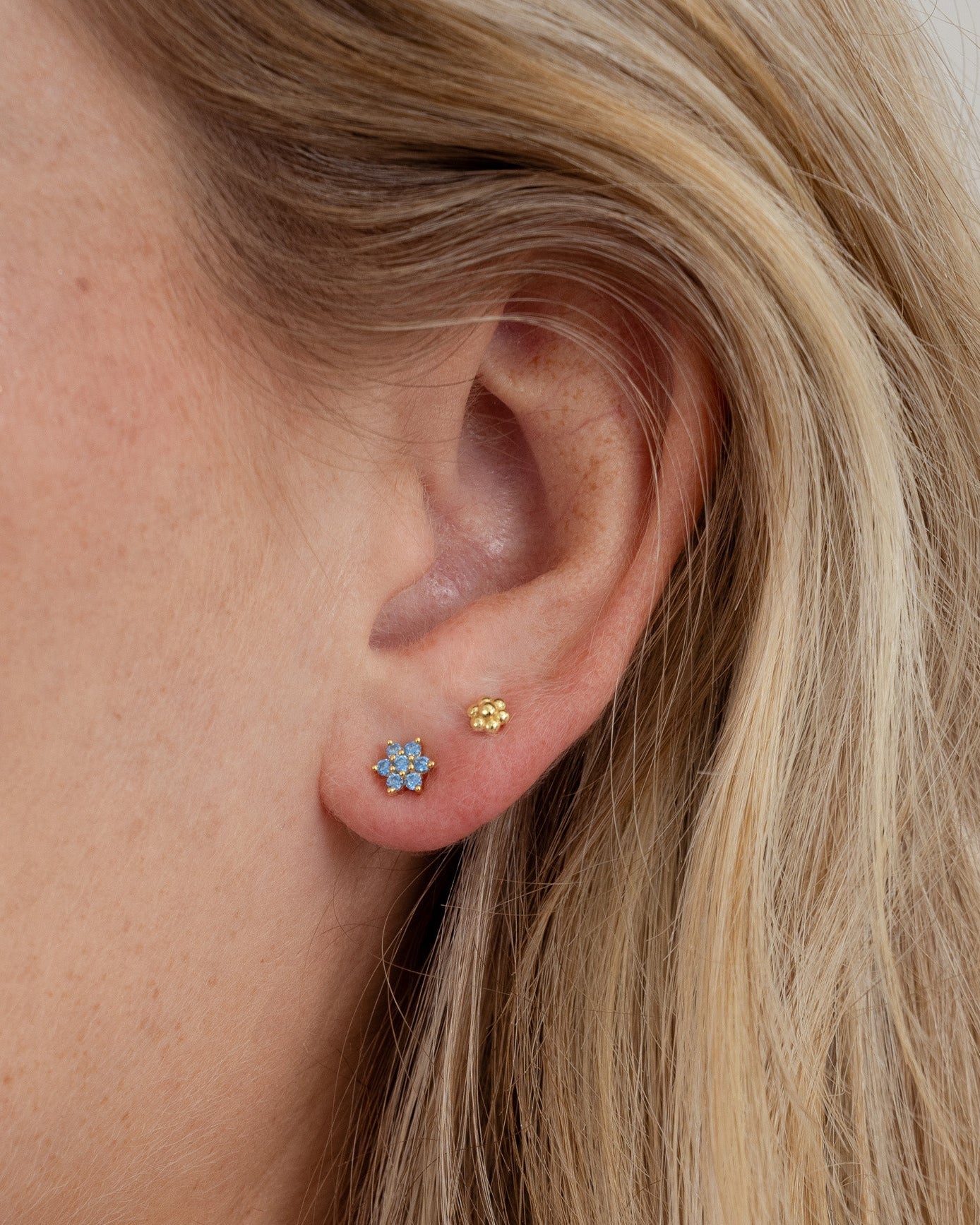 aquamarine flower stud earrings in gold on model