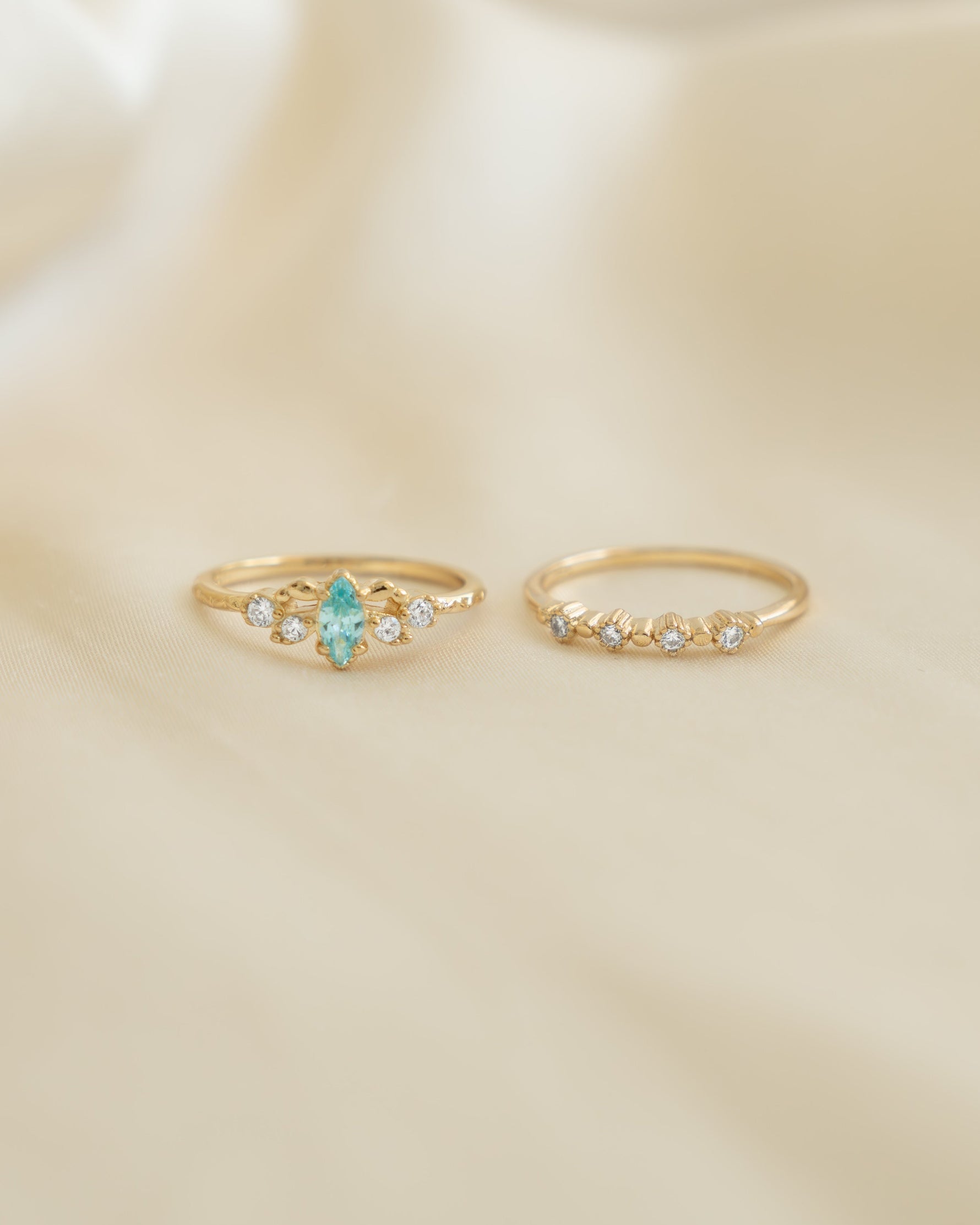 Gold aquamarine ring set by Sami Jewels featuring multiple elegant rings with aquamarine gemstones, front view display.