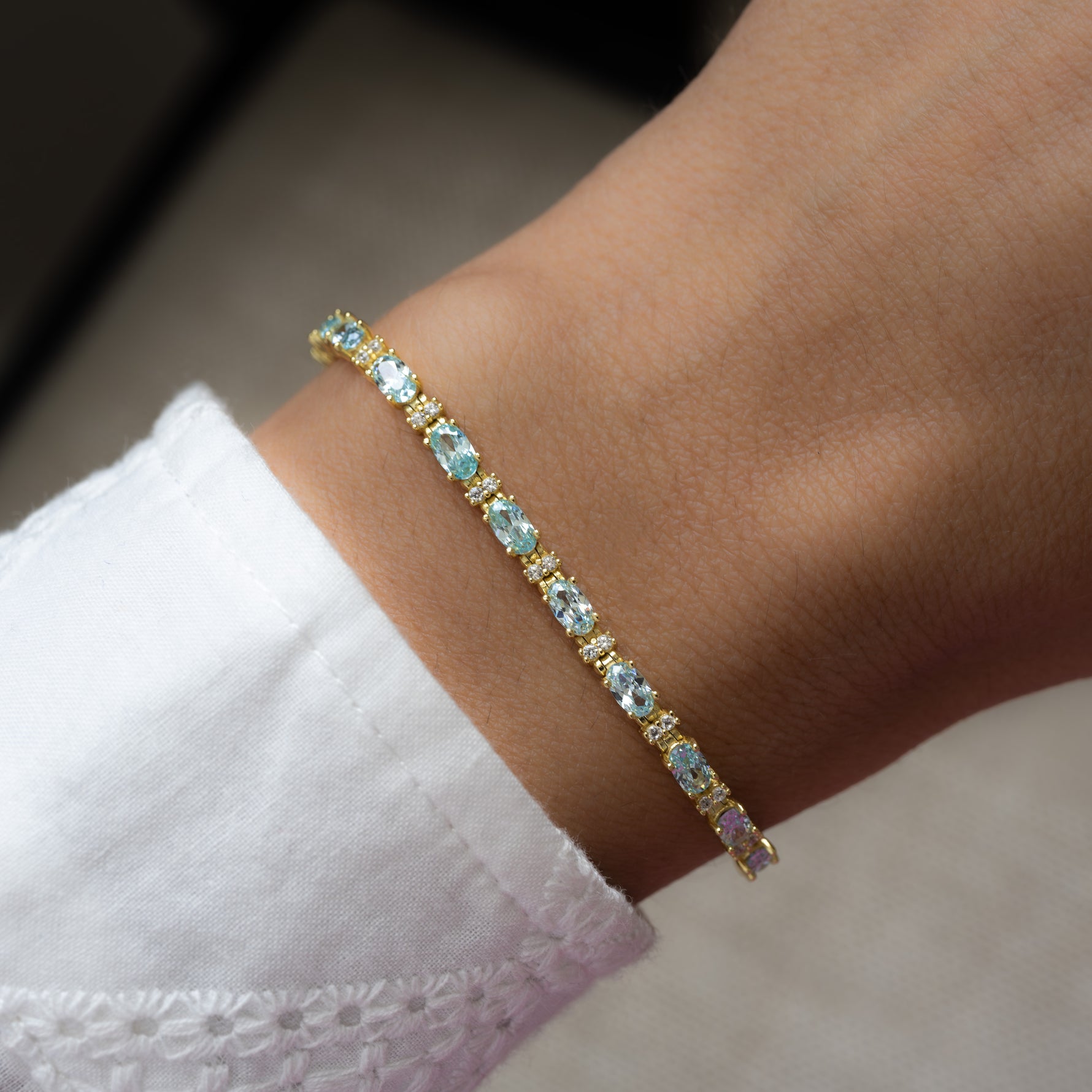 model wearing gold aquamarine tennis bracelet
