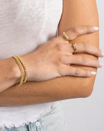 Gold baguette croissant ring by Sami Jewels showcasing detailed pastry design on a sleek band.
