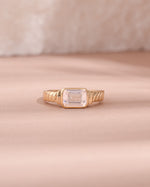 gold diamond baguette cut statement ring light pink background 