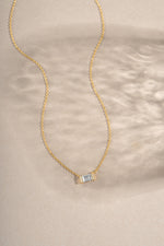 Gold Baguette Necklace by Sami Jewels featuring a sparkling diamond baguette pendant on a delicate chain.