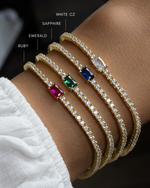 Sami Jewels tennis bracelet with baguette diamonds and colorful birthstone charms on a model's wrist.