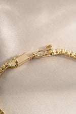 Gold tennis bracelet with baguette diamond charms and secure clasp, crafted by Sami Jewels.