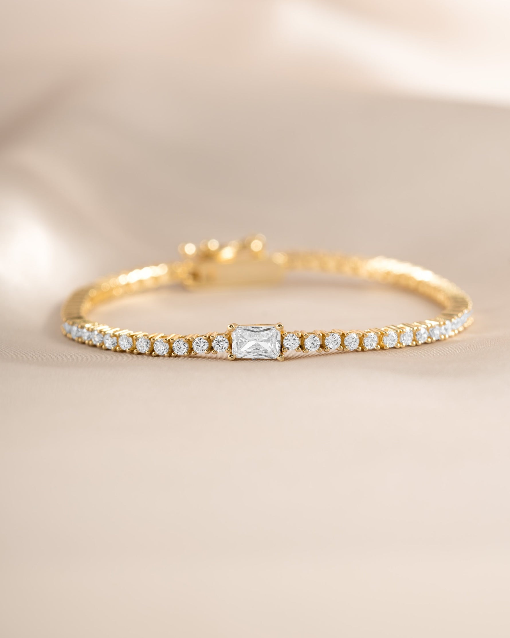Gold tennis bracelet with baguette diamond charms from Sami Jewels, featuring a close-up front view of the elegant jewelry piece.