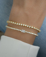 Gold tennis bracelet with baguette diamond charm worn on a model, showcasing elegant jewelry by Sami Jewels.