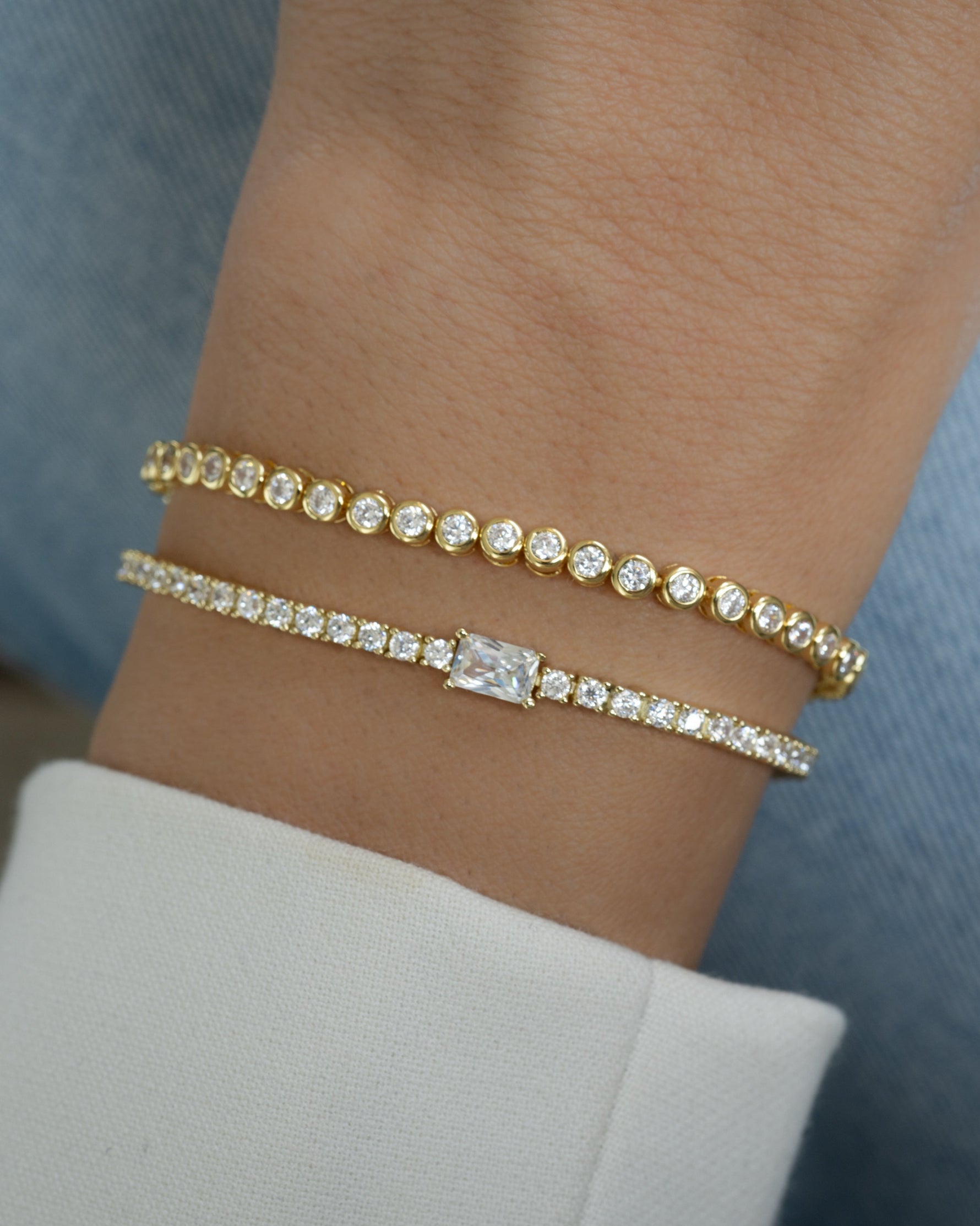 Gold tennis bracelet with baguette diamond charm worn on a model, showcasing elegant jewelry by Sami Jewels.