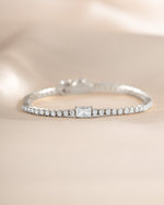 Silver tennis bracelet by Sami Jewels with baguette cubic zirconia charms and sparkling diamond accents.