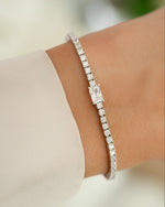 Silver tennis bracelet with baguette diamond charms worn on a model, showcasing elegant jewelry by Sami Jewels.