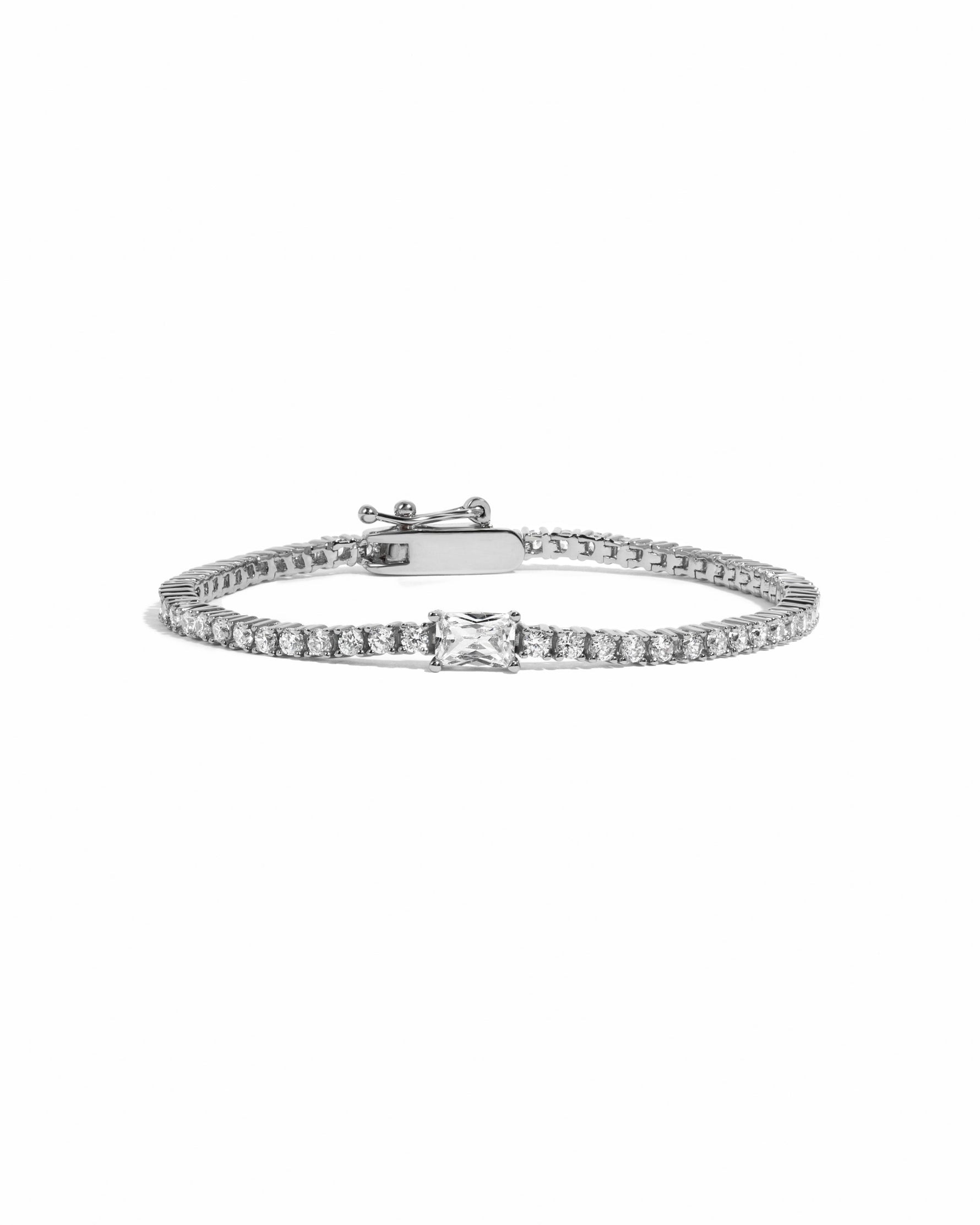 Silver tennis bracelet with baguette diamond charm by Sami Jewels, featuring a sleek design on a white background.