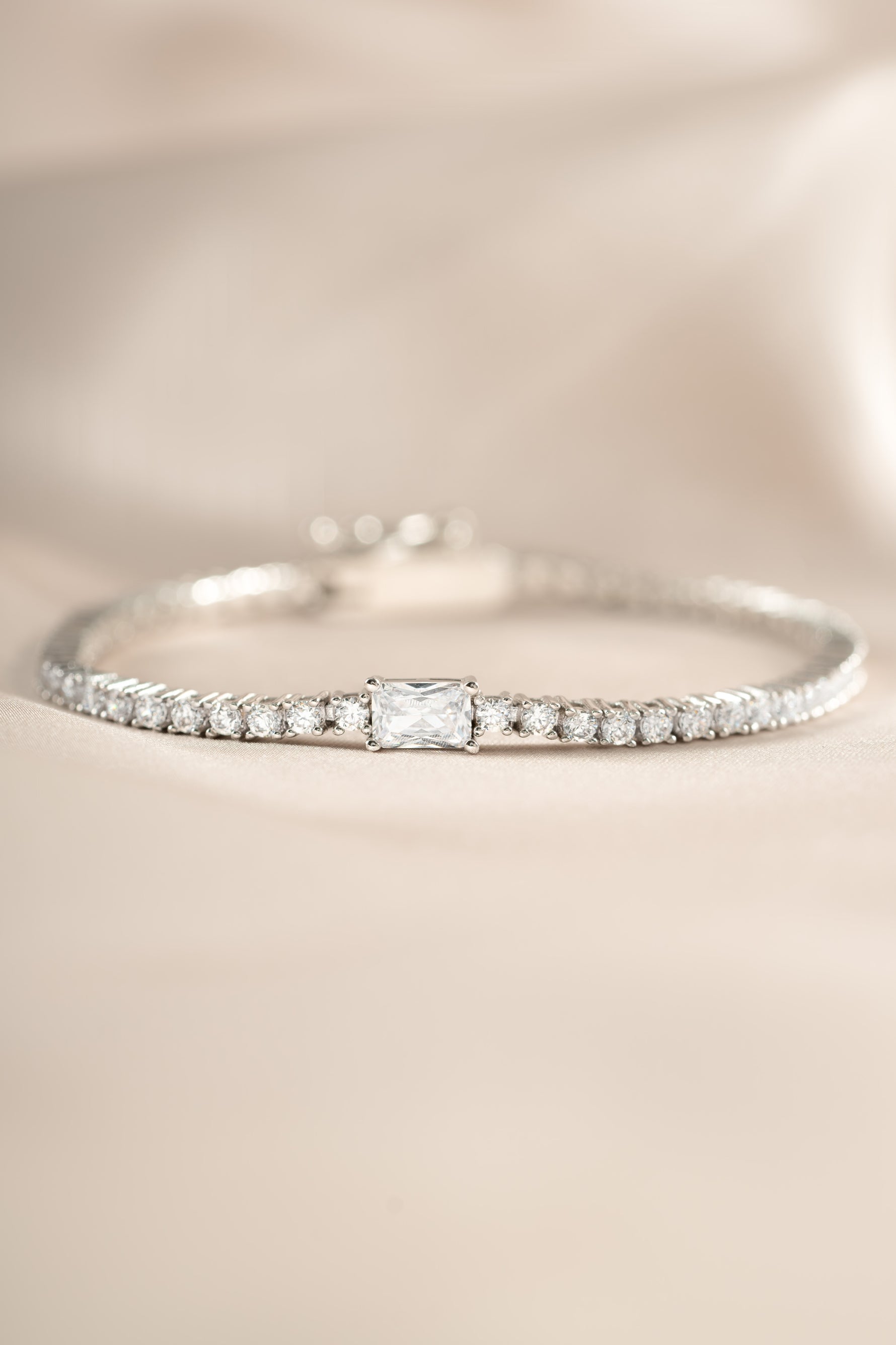 Silver tennis bracelet by Sami Jewels featuring a baguette diamond charm and elegant design.