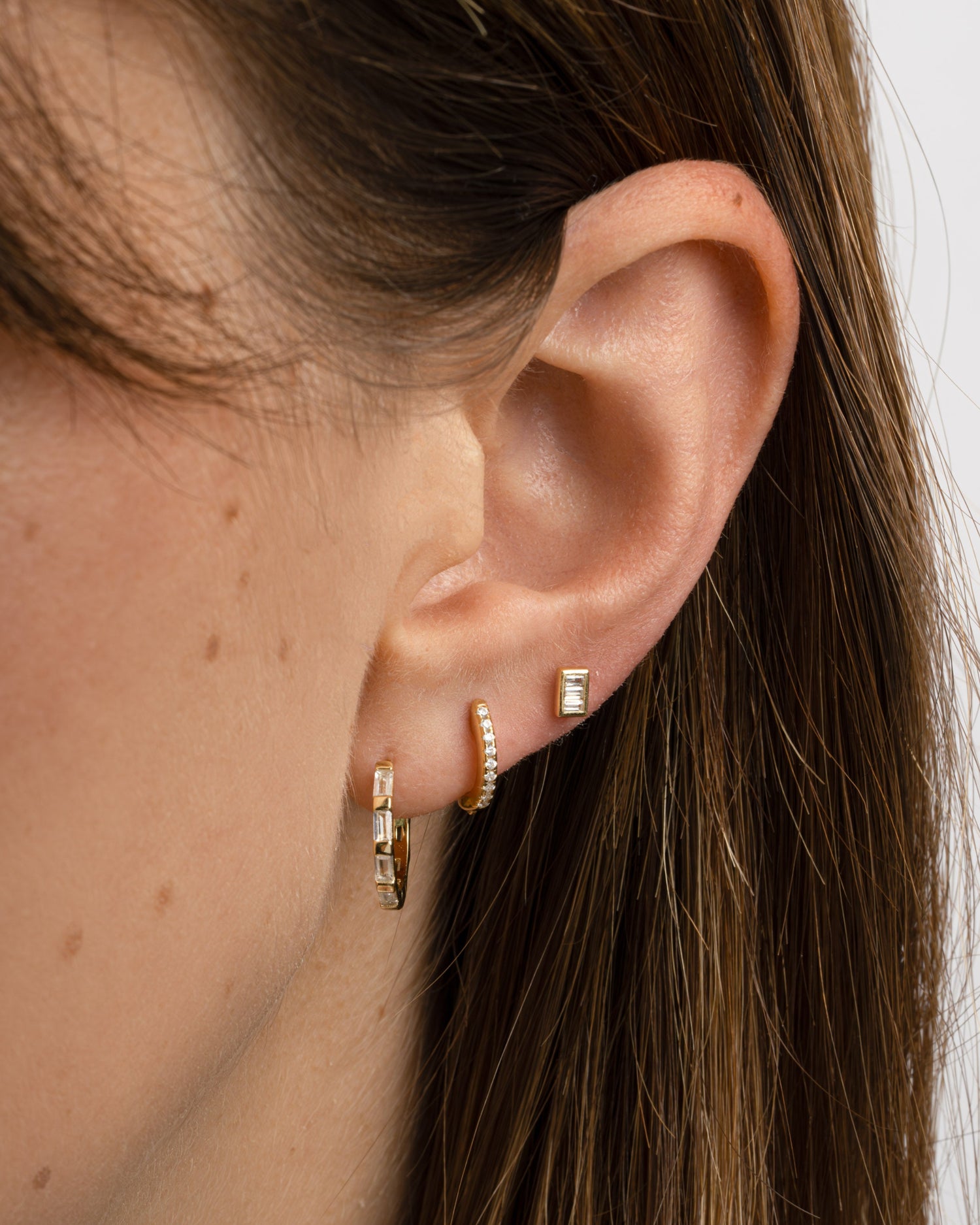 Gold baguette hoop earrings by Sami Jewels, stacked style, featuring sleek rectangular design on a model.
