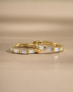 Close-up of gold baguette hoop earrings by Sami Jewels, showcasing sleek, rectangular design and polished finish.