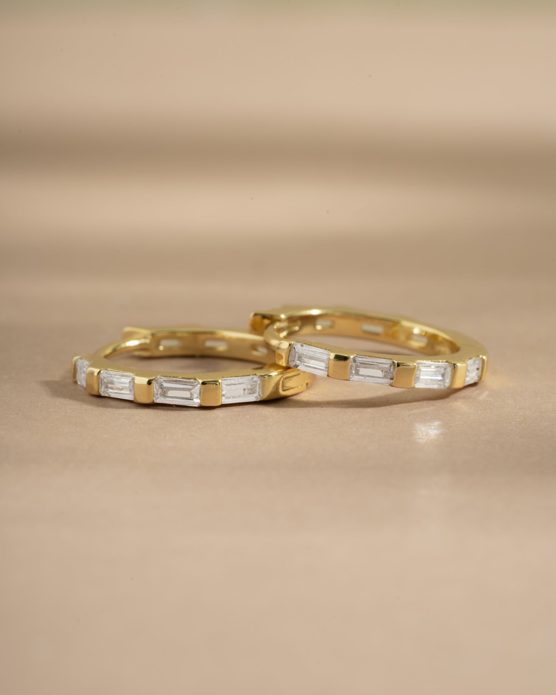 Close-up of gold baguette hoop earrings by Sami Jewels, showcasing sleek, rectangular design and polished finish.