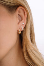 Gold Daryl-Ann's Baguette Hoops earrings by Sami Jewels, featuring sleek baguette-shaped huggie design on a model.