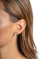 Sterling silver small baguette huggie earrings worn on a model, featuring sleek, rectangular baguette design by Sami Jewels.