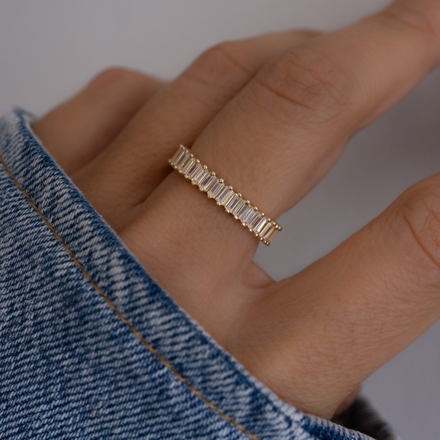 model wearing an eternity ring that wraps around the finger, its stones adding dimension and texture. 
