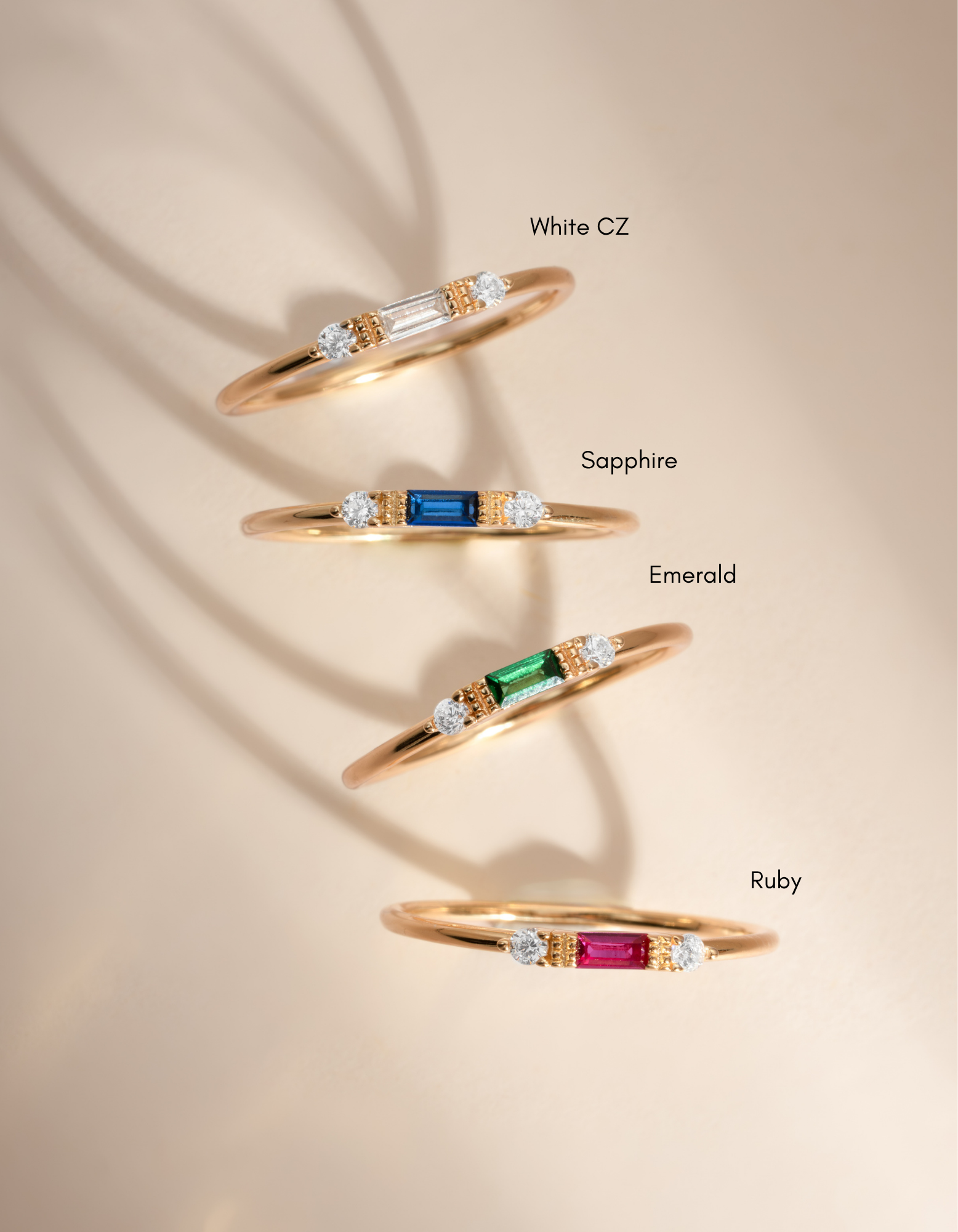White CZ baguette ring by Sami Jewels featuring gold band and various birthstone options, showcasing elegant jewelry design.
