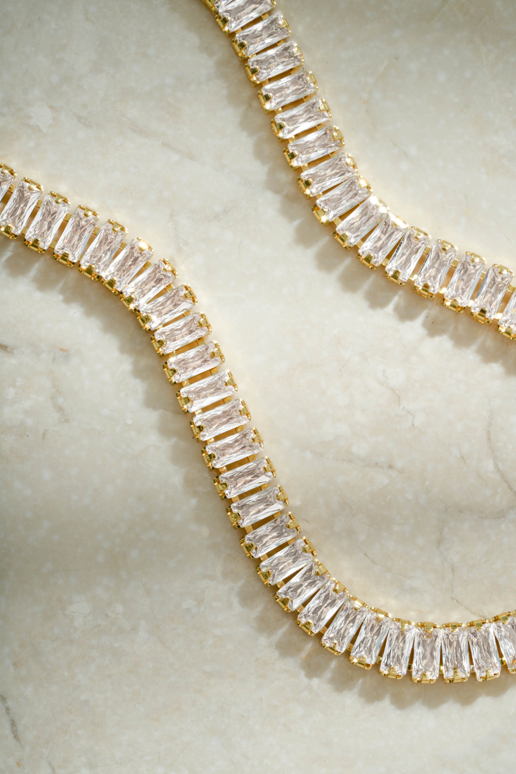 Close-up of Sami Jewels gold baguette tennis bracelet showcasing sleek rectangular stones and delicate chain design.