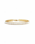 Gold Baguette Tennis Bracelet by Sami Jewels with rectangular cut gemstones displayed on a white background.
