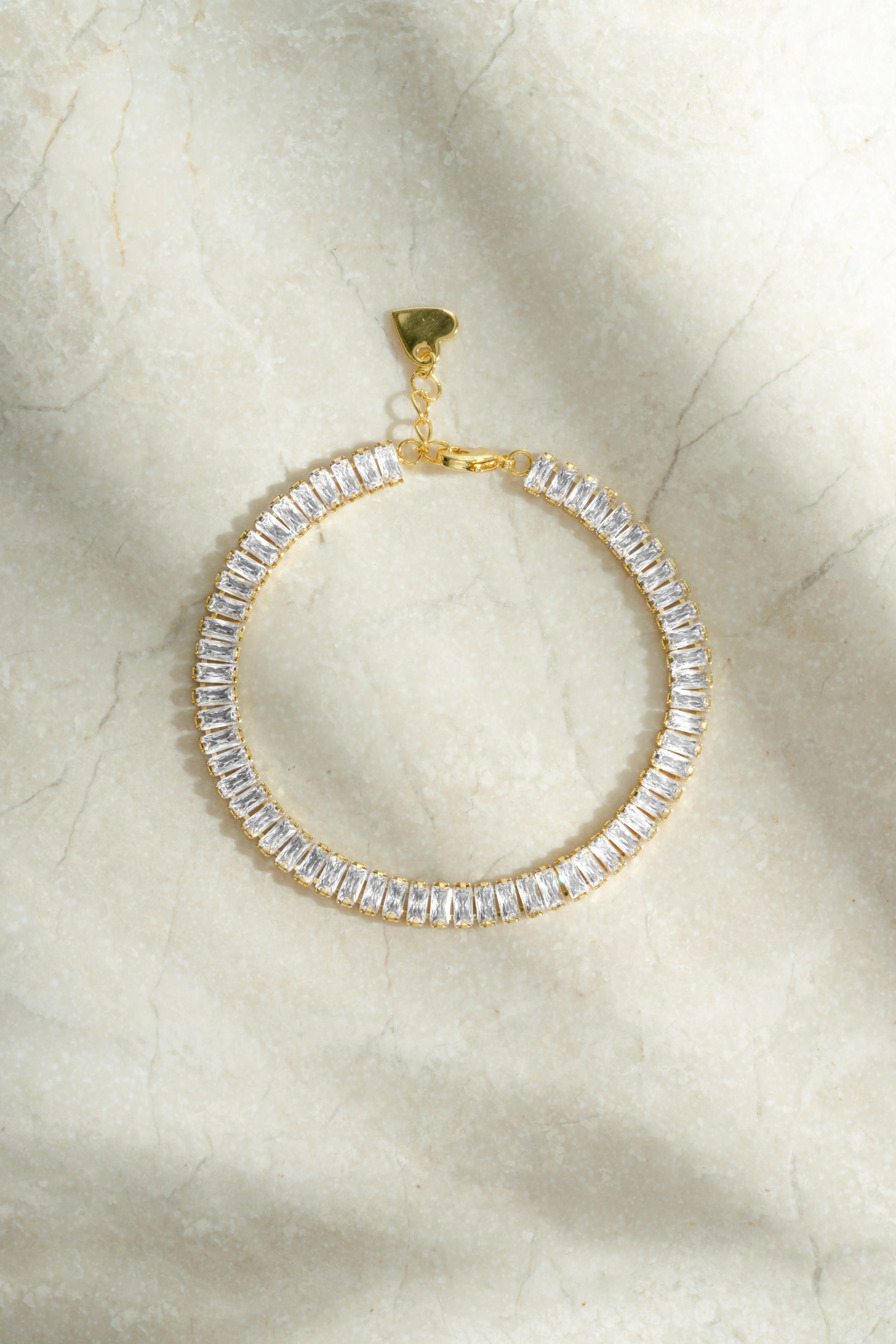 Gold Baguette Tennis Bracelet by Sami Jewels featuring rectangular cut gemstones and a sleek, elegant design.