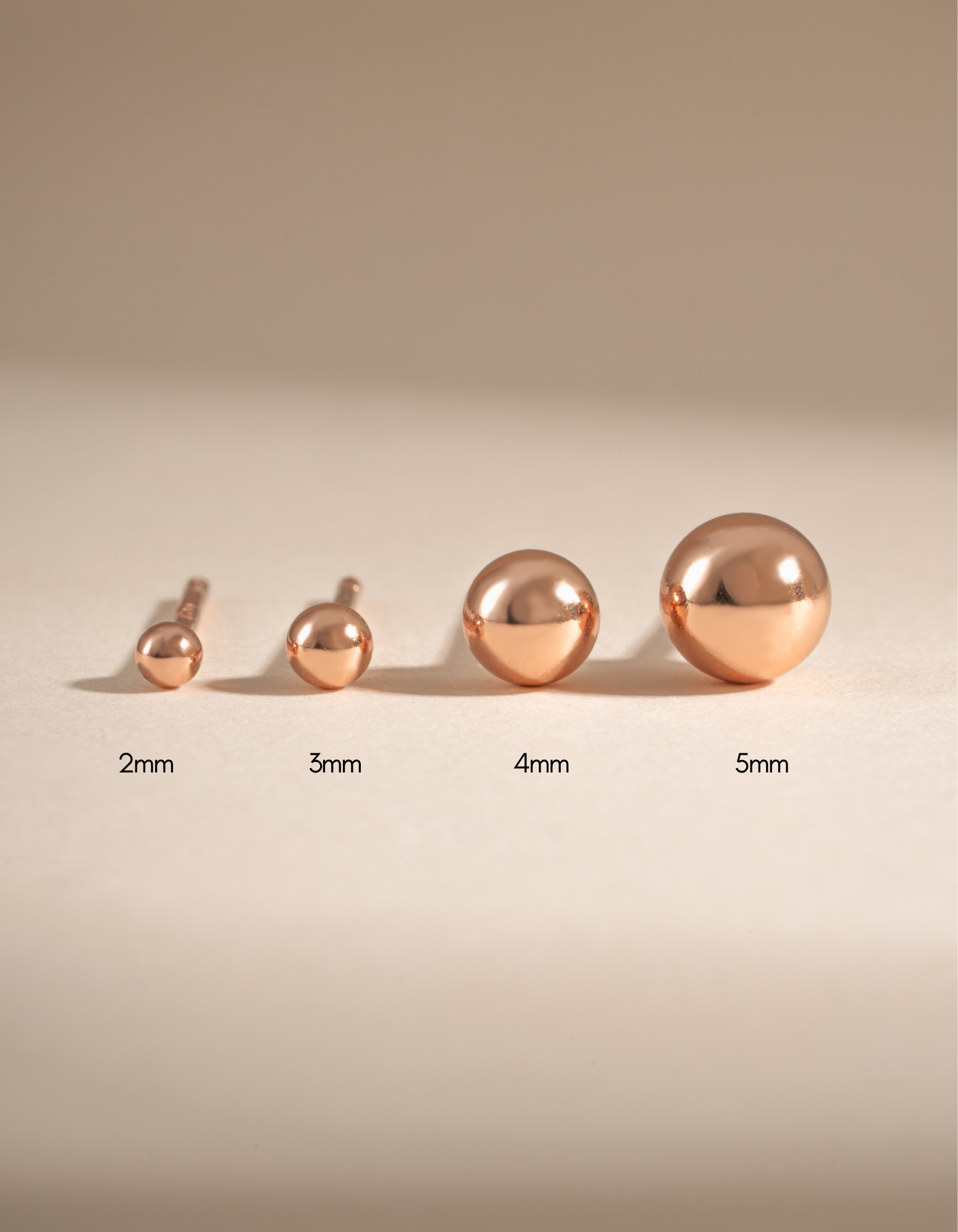 Rose gold 4mm ball stud earrings by Sami Jewels, showcasing shiny spherical stud earrings on a plain background.