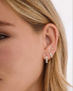 Gold Sami Jewels bezel 3 stone huggie hoop earrings, close-up image showing their elegant design and secure hinge closure.