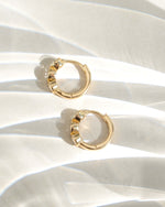 Gold Bezel 3 Stone Huggie Hoop Earrings by Sami Jewels, showcasing sleek hoops with three bezel-set stones in a close-up profile view.