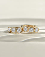 Gold Sami Jewels Bezel 3 Stone Huggie Hoop Earrings featuring small bezel-set stones on a delicate hoop design.