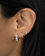 Sterling silver Bezel 3 Stone Huggie Hoop Earrings by Sami Jewels, shown on a model with small, stylish hoop earrings.