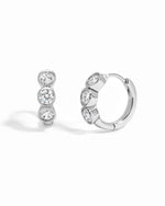 Sterling silver Bezel 3 Stone Huggie Hoop Earrings by Sami Jewels with three sparkling stones on a white background.