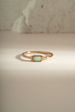 Gold bezel baguette opal ring by Sami Jewels, front view showcasing the elegant rectangular opal gemstone and sleek band.