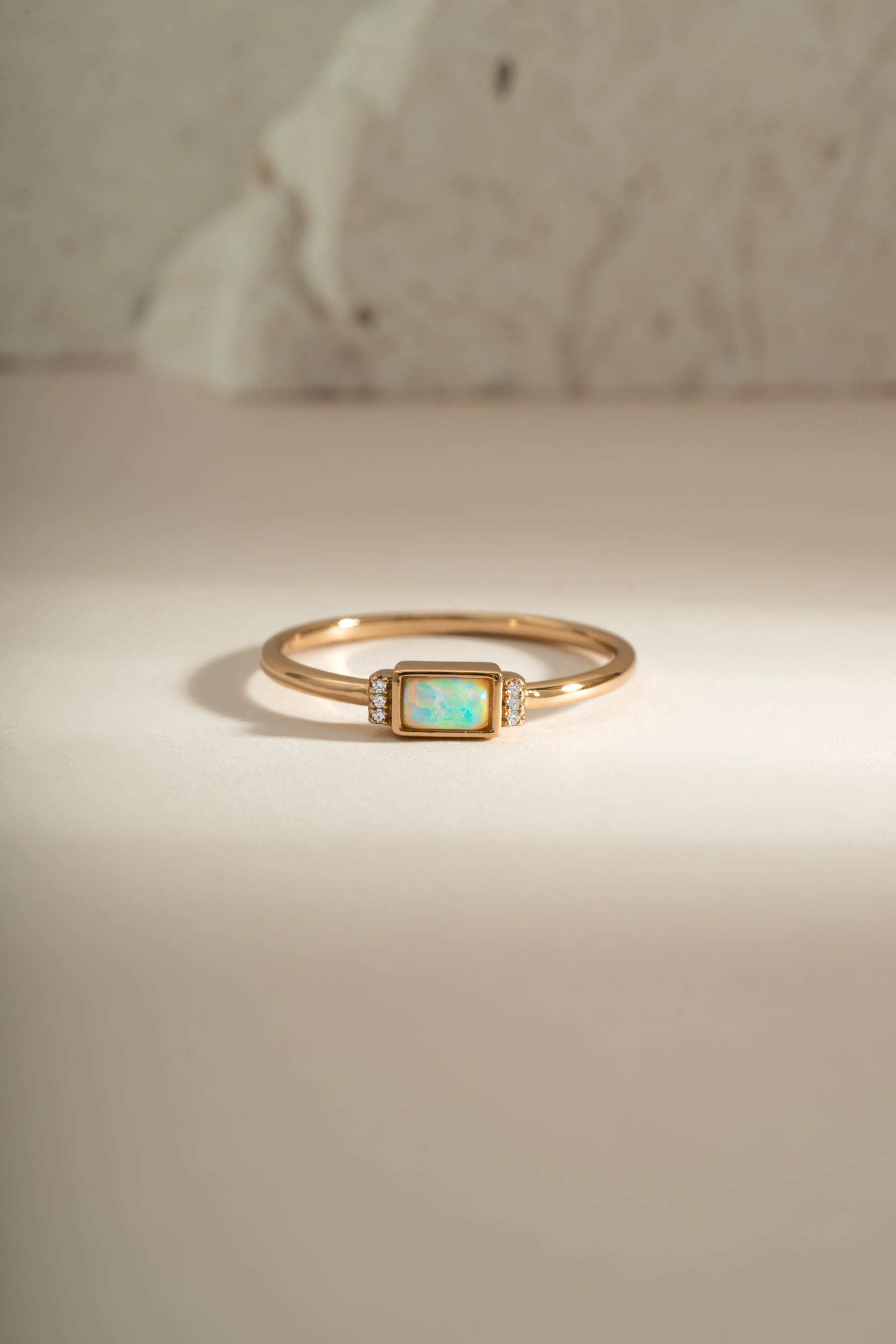 Gold bezel baguette opal ring by Sami Jewels, front view showcasing the elegant rectangular opal gemstone and sleek band.