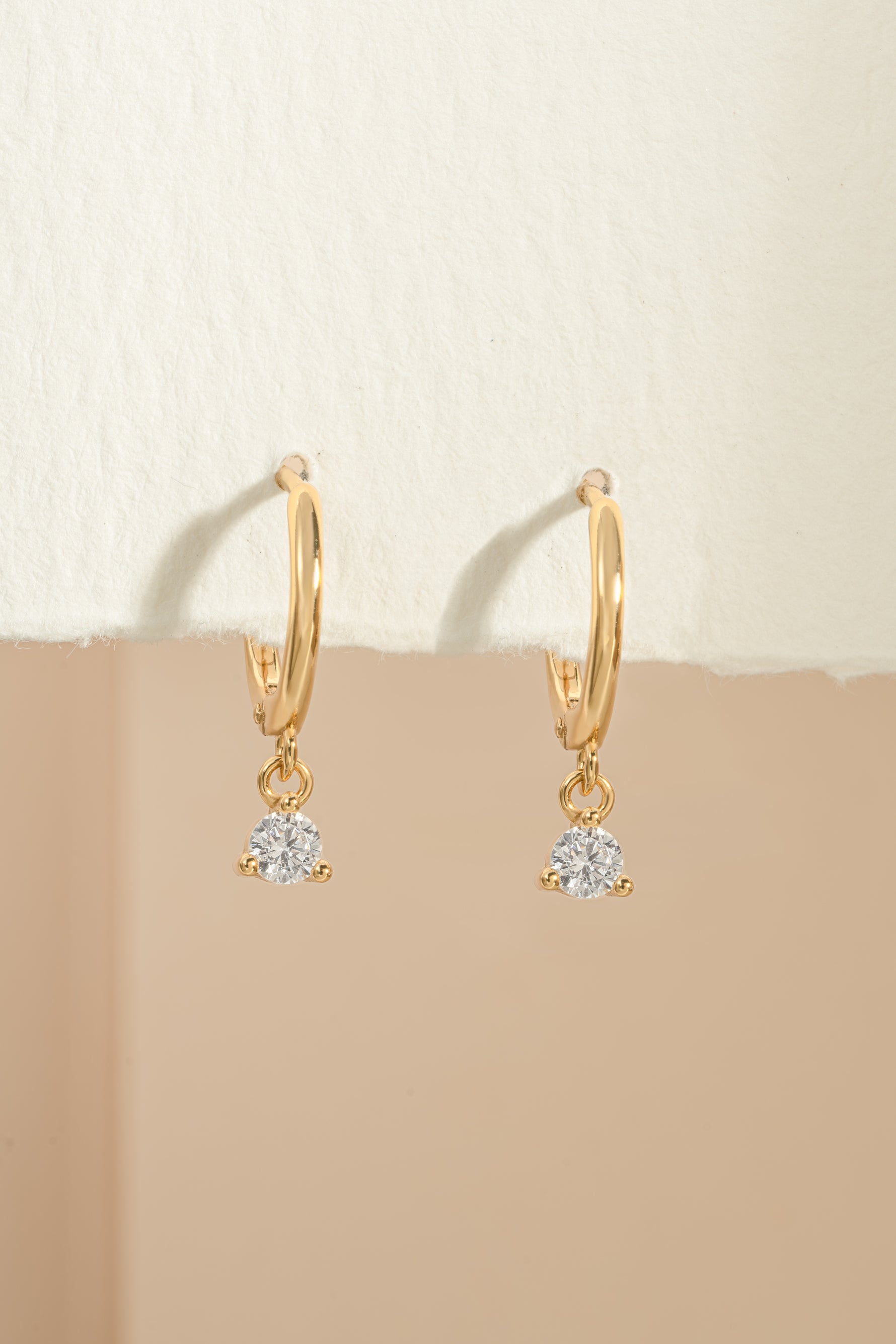 Gold bezel charm huggie earrings by Sami Jewels featuring small, stylish hoop design with decorative charm details.
