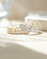 Close-up of Sami Jewels bezel emerald cut eternity band ring featuring gold and sterling silver with a continuous row of emerald-cut stones.