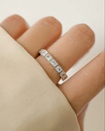 Sterling silver bezel emerald cut eternity ring from Sami Jewels featuring a continuous row of rectangular-cut gemstones.