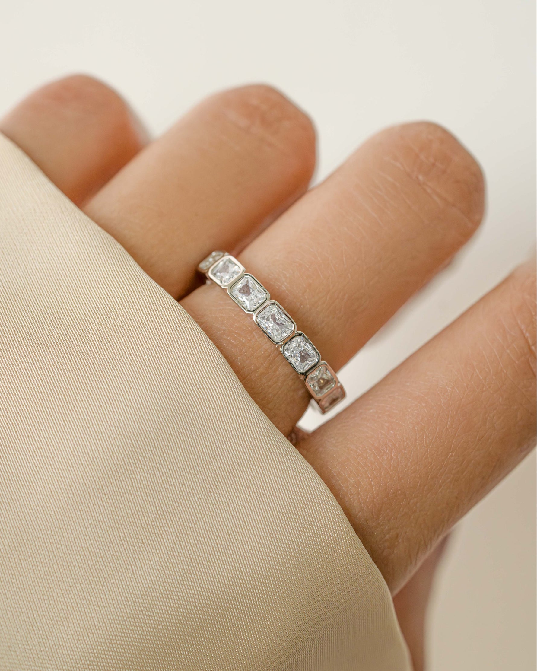 Sterling silver bezel emerald cut eternity ring from Sami Jewels featuring a continuous row of rectangular-cut gemstones.